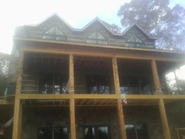 Dormers and porch framing on a large log home under construction — Roof Coating work by our crew in Newhall